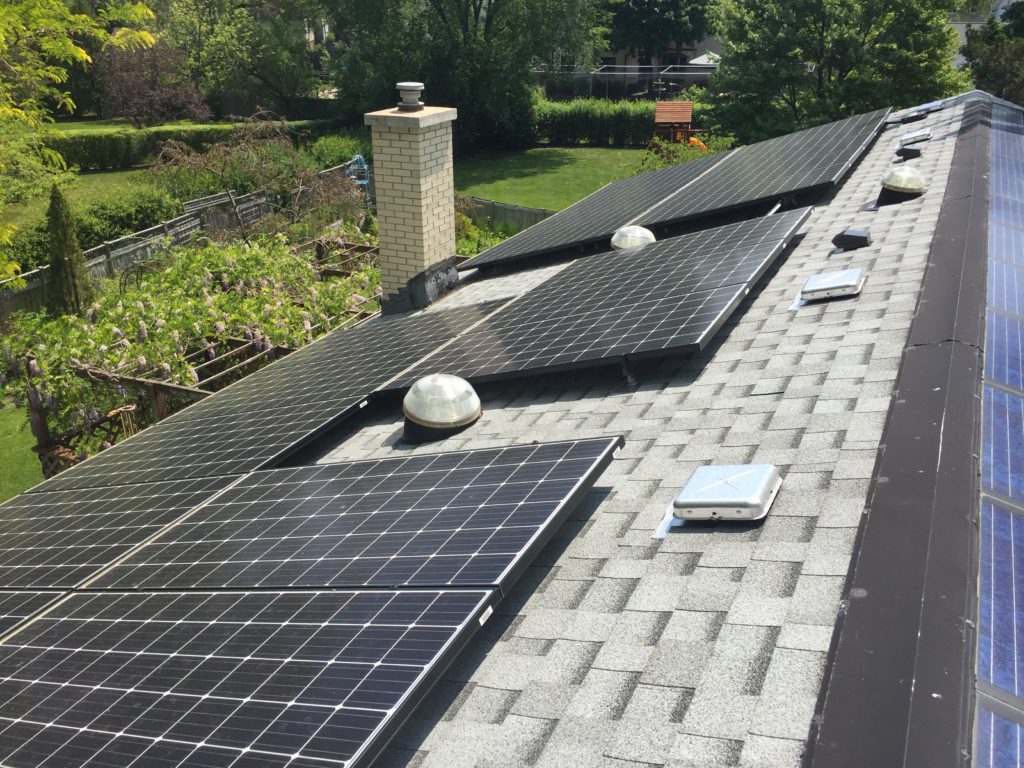 Solar panels on a house with a garden trellis in the backyard